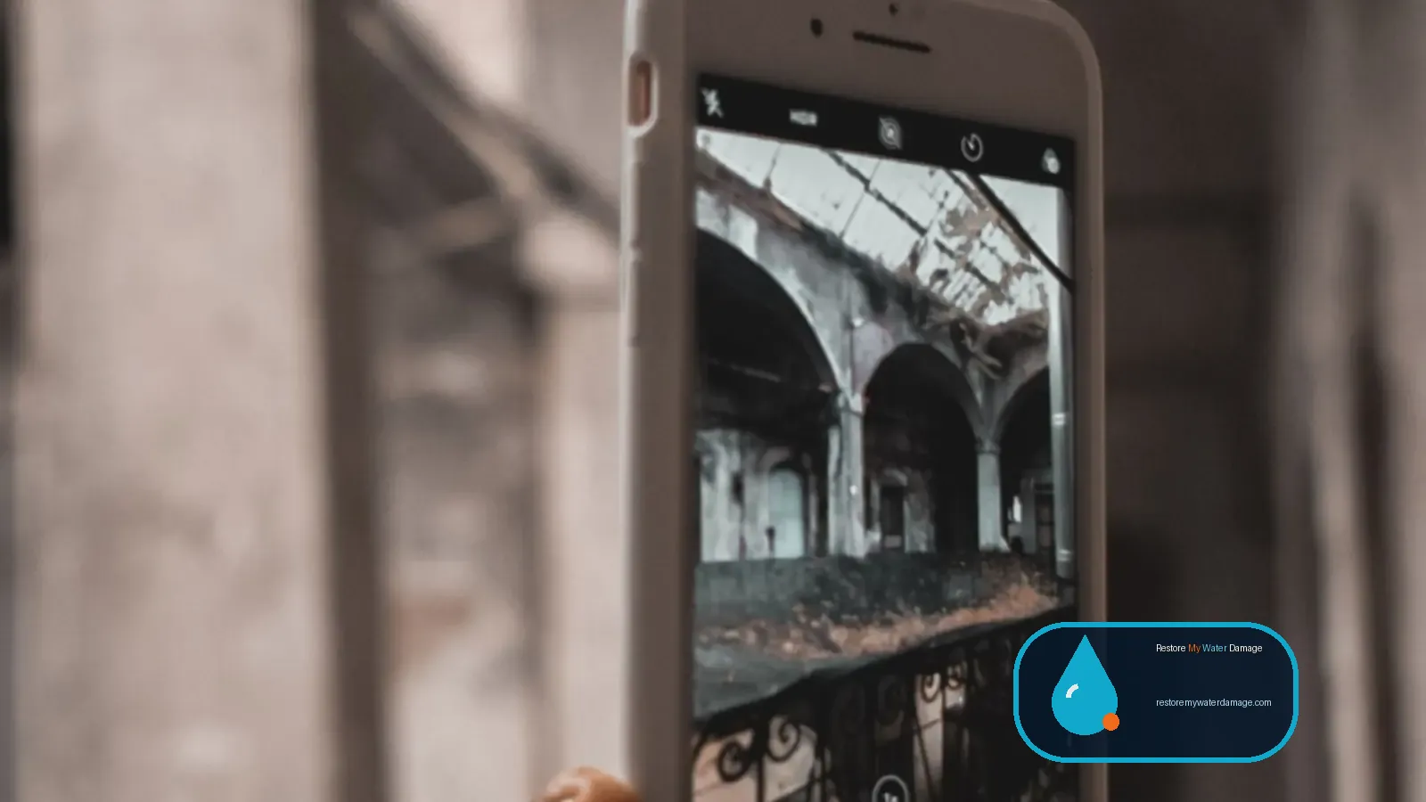 Smartphone photographing interior damage to document an insurance claim for flood damage restoration