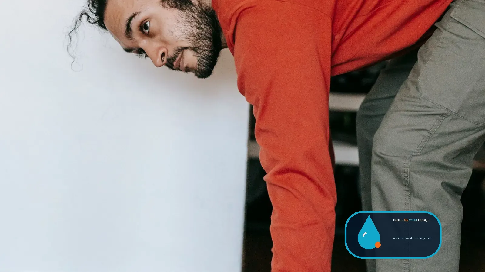 Man pulling up a carpet from the floor during water damage cleanup