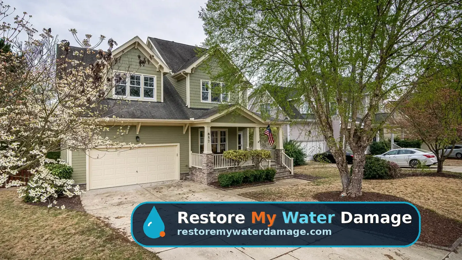 Suburban home with a long driveway and mature trees, needing water damage restoration in Cherry Hill