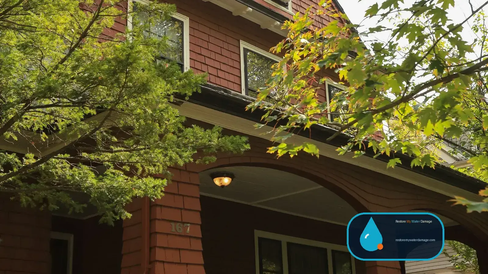 Craftsman home with stone porch among lush green trees, typical for water damage restoration in Oregon