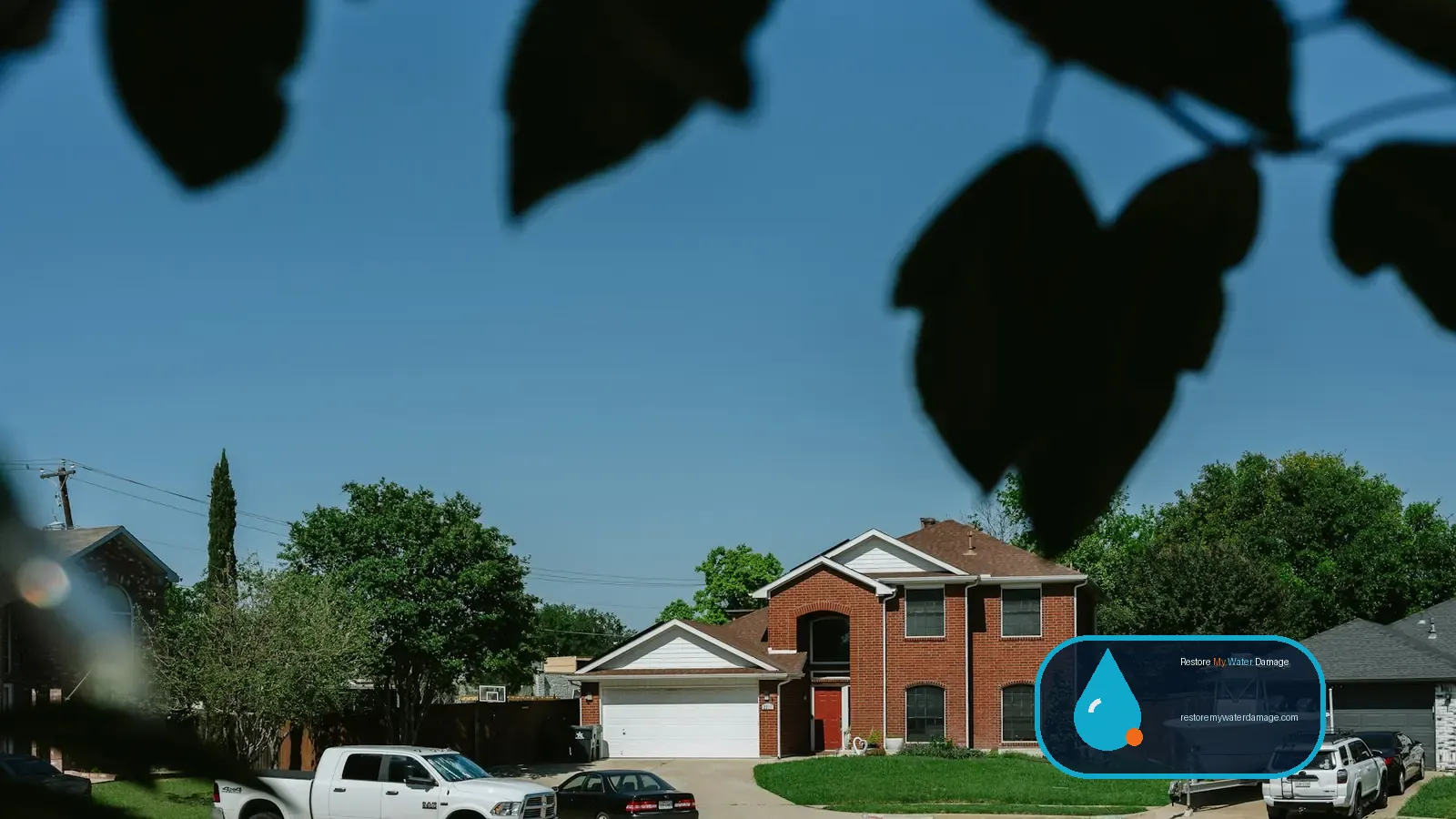 Two-story brick suburban home with an attached garage and driveway, typical of water damage restoration Plano Richardson, TX