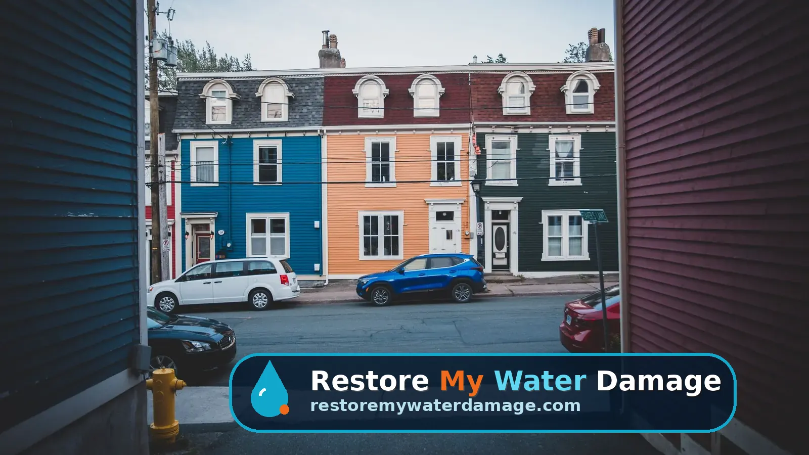 Colorful attached row houses and parked cars on a city street, needing water damage restoration in Trenton